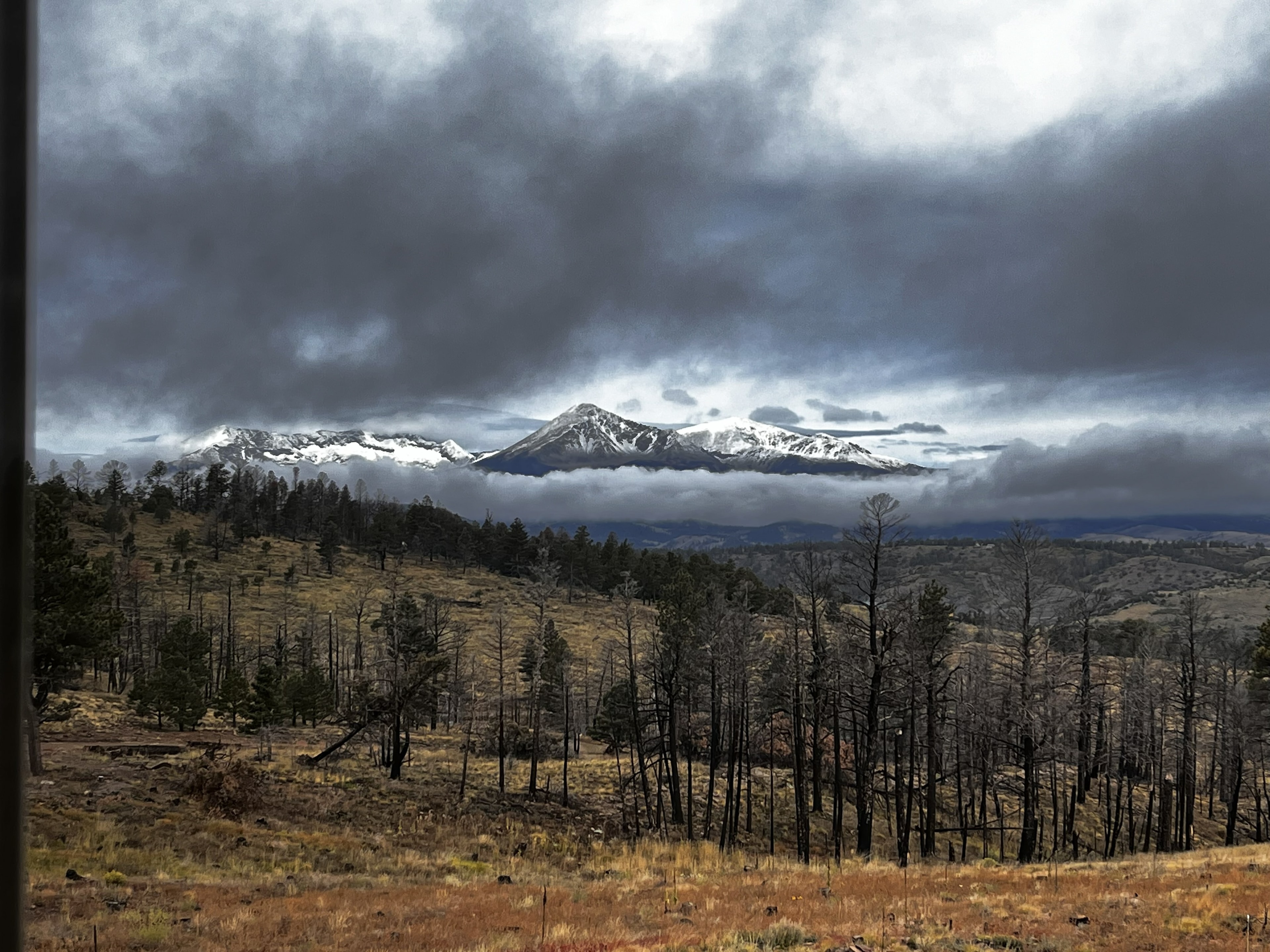 Snow-capped Sangre de Cristo peaks under dramatic storm clouds